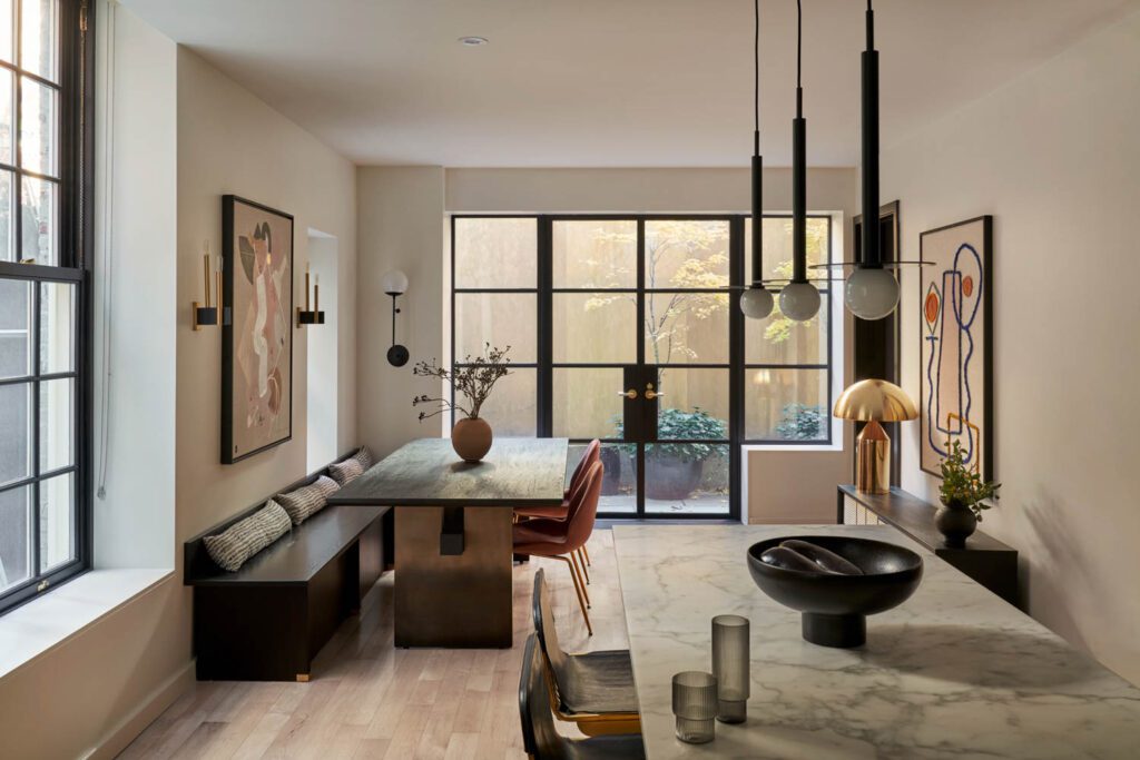 Inmod dining chairs surround the Burke Décor table. The banquette and cushions were custom made and the vase is by Shoppe Amber Interiors.