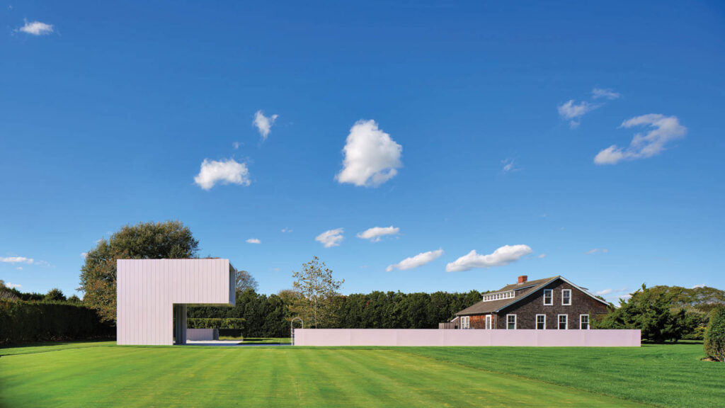 an L-shaped guest house with rose-toned metal paneling