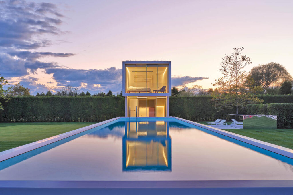 a pool with a guest house seated above