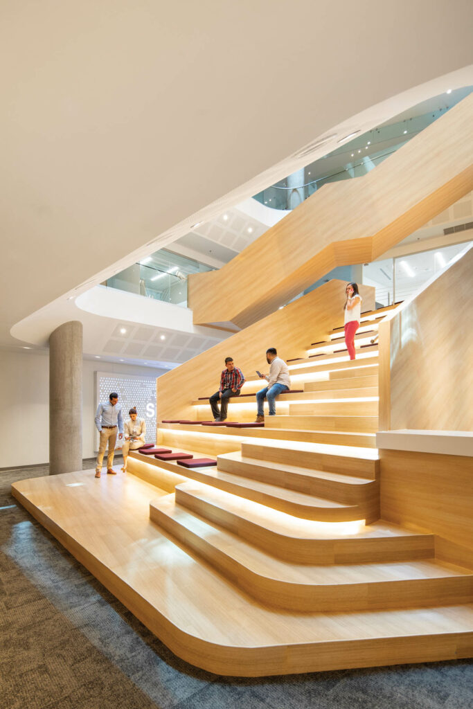 people chat on wooden risers in an office