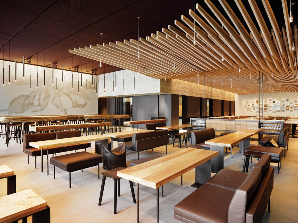 A sculptural ceiling at In Situ with wood tables and brown chairs