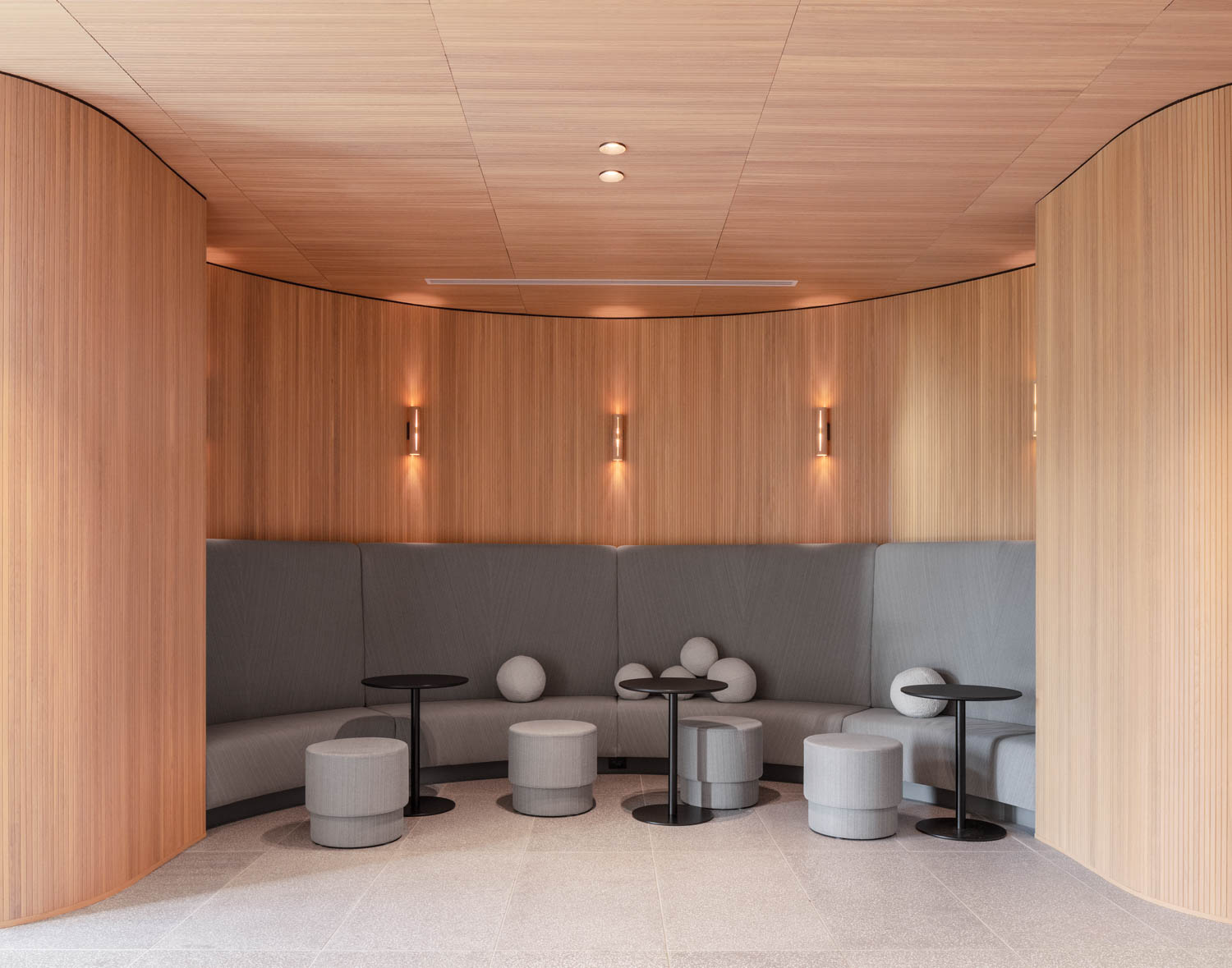 grey upholstered seating against a pale wood wall