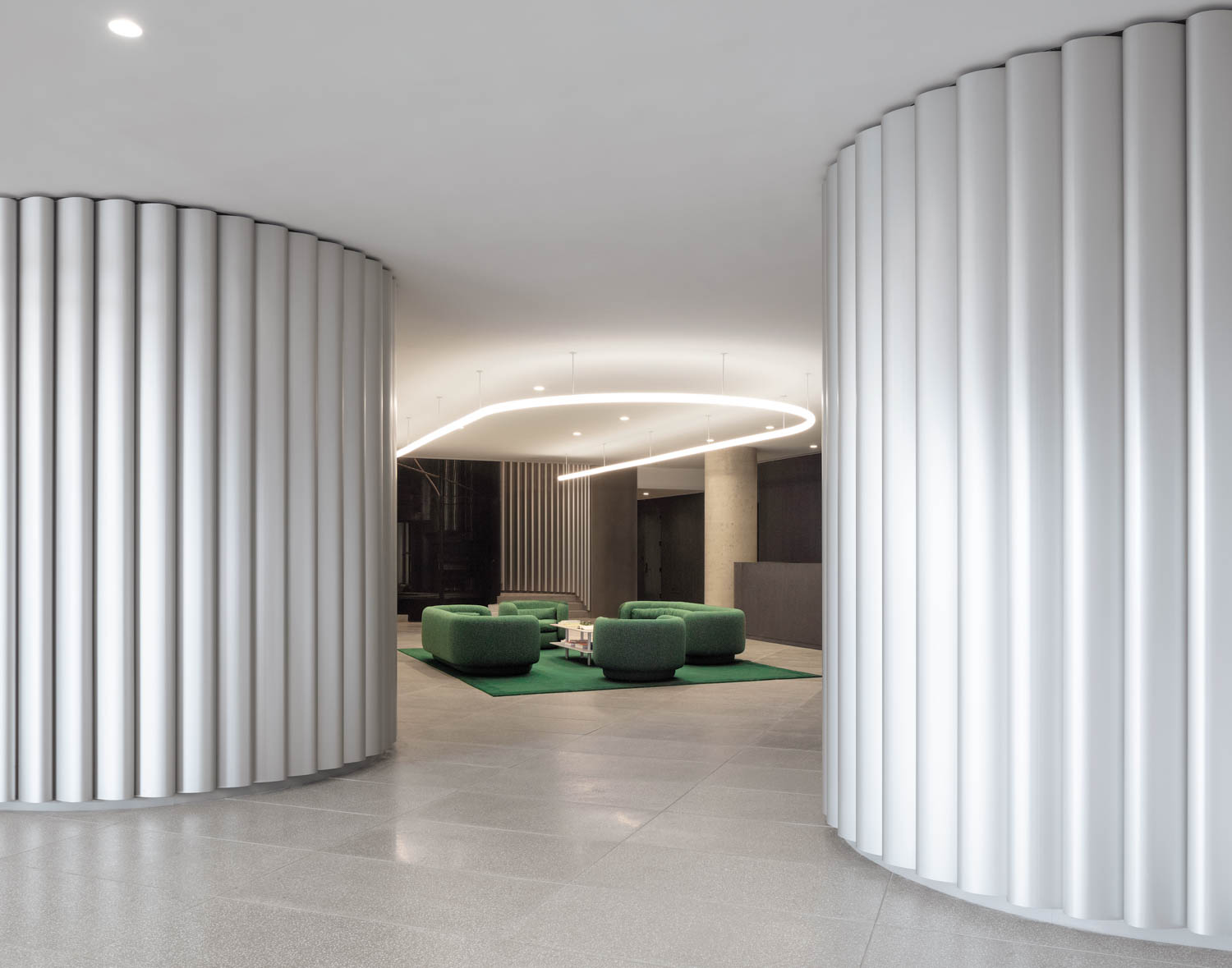 curved walls fronted by anodized-aluminum opens to a lounge area in a residential complex