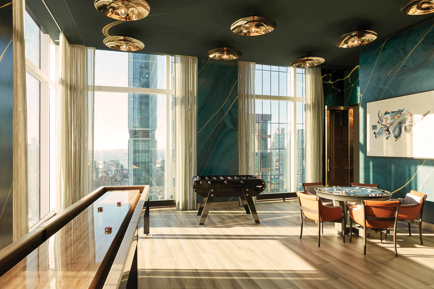 a common area in a residential building with games to play and views of NYC