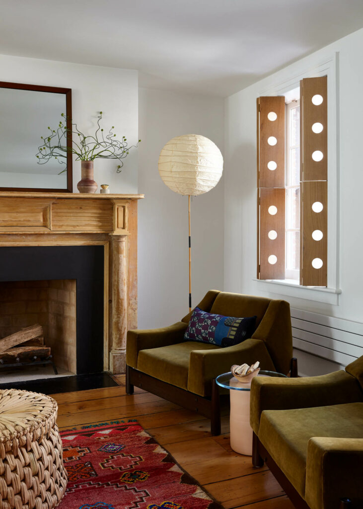 green velvet chairs in front of fireplace in an earthy toned living room