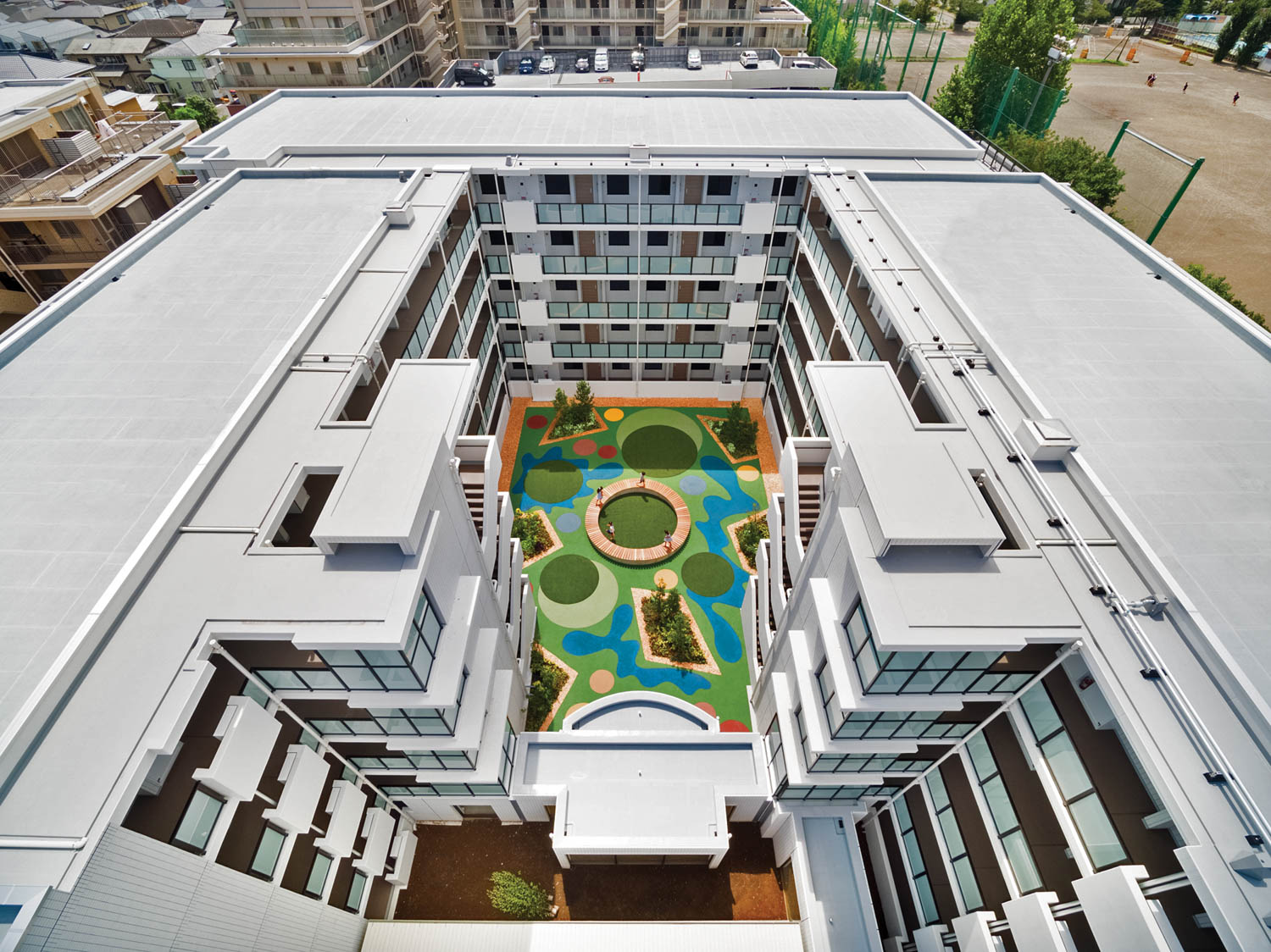 an aerial view of a colorfully designed turf in the middle of a condo building