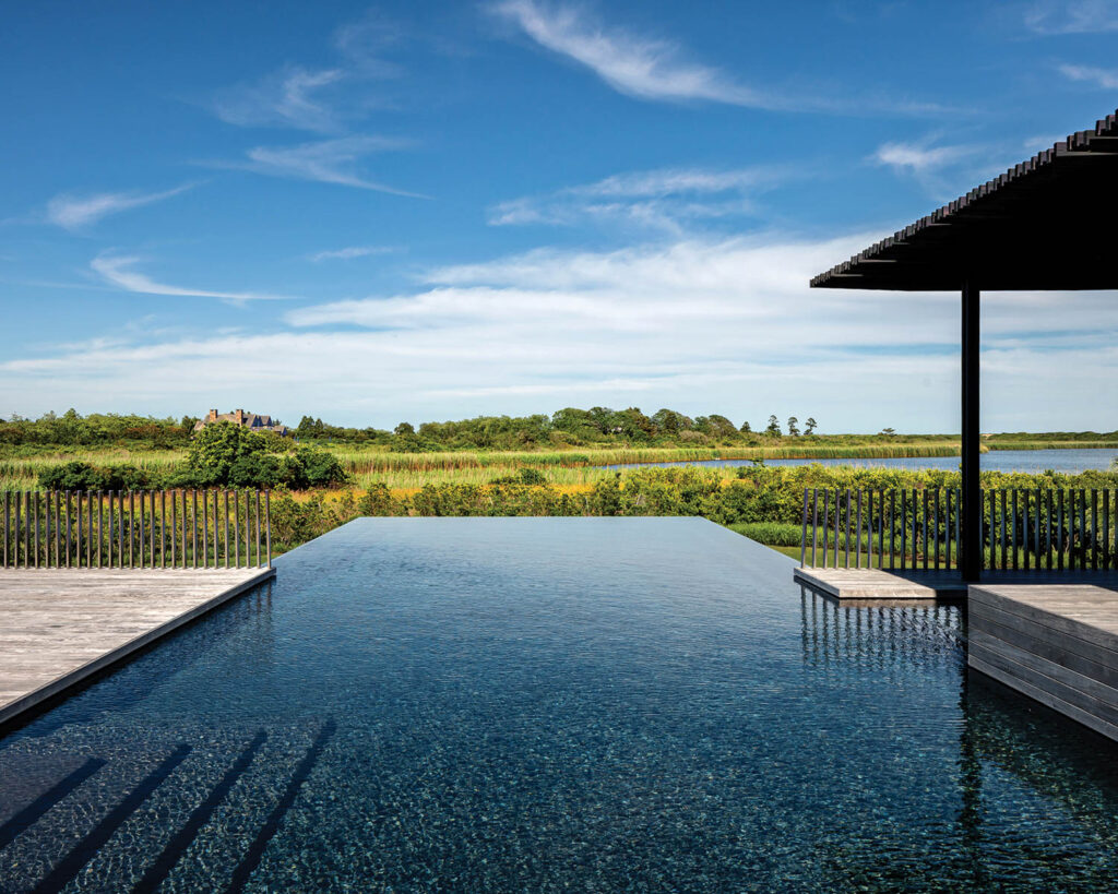 an infinity pool overlooking a grassy landscape