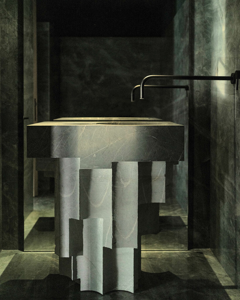 a sculptural dark green sink in a bathroom