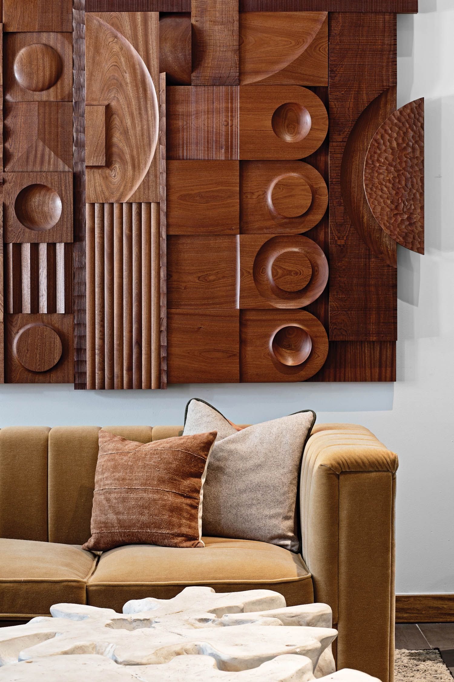 carved walnut wall art above a sofa in a rental complex