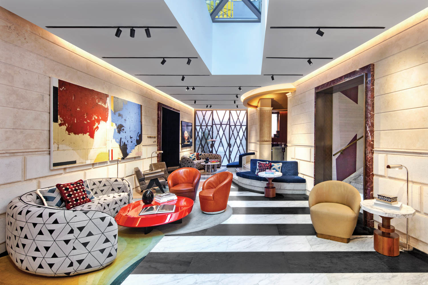 a lobby with an Italian marble floor and a glass end wall is framed with bronzed steel in a W pattern