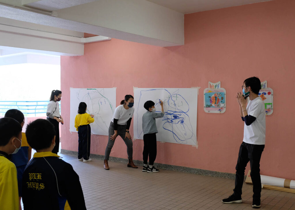 people standing in front of large sheets of paper on pink walls