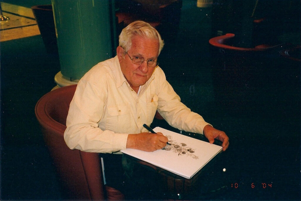 picture of John P. Eberhard sitting at a table drawing