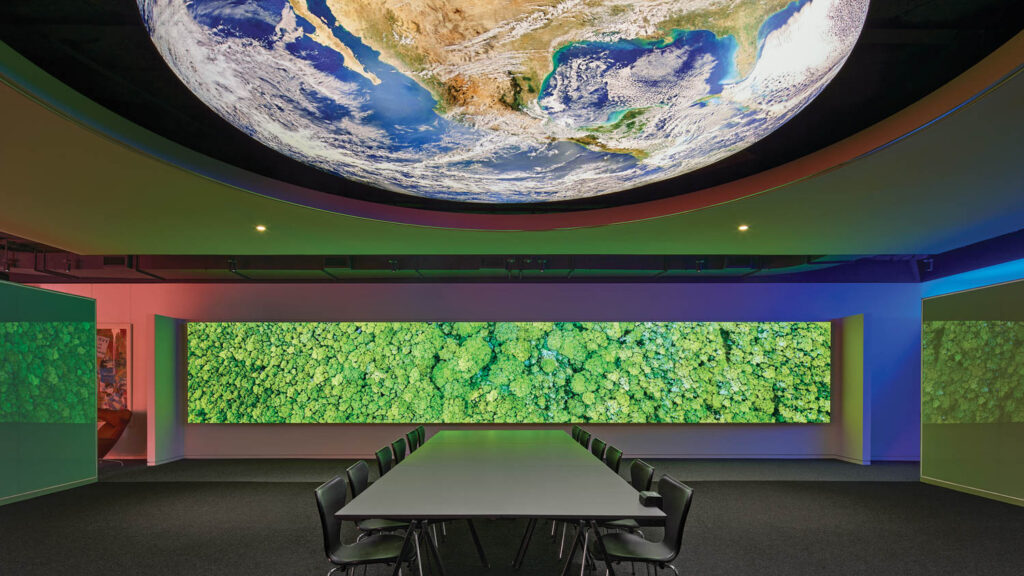 conference room with a bright green screen and digital view of a globe