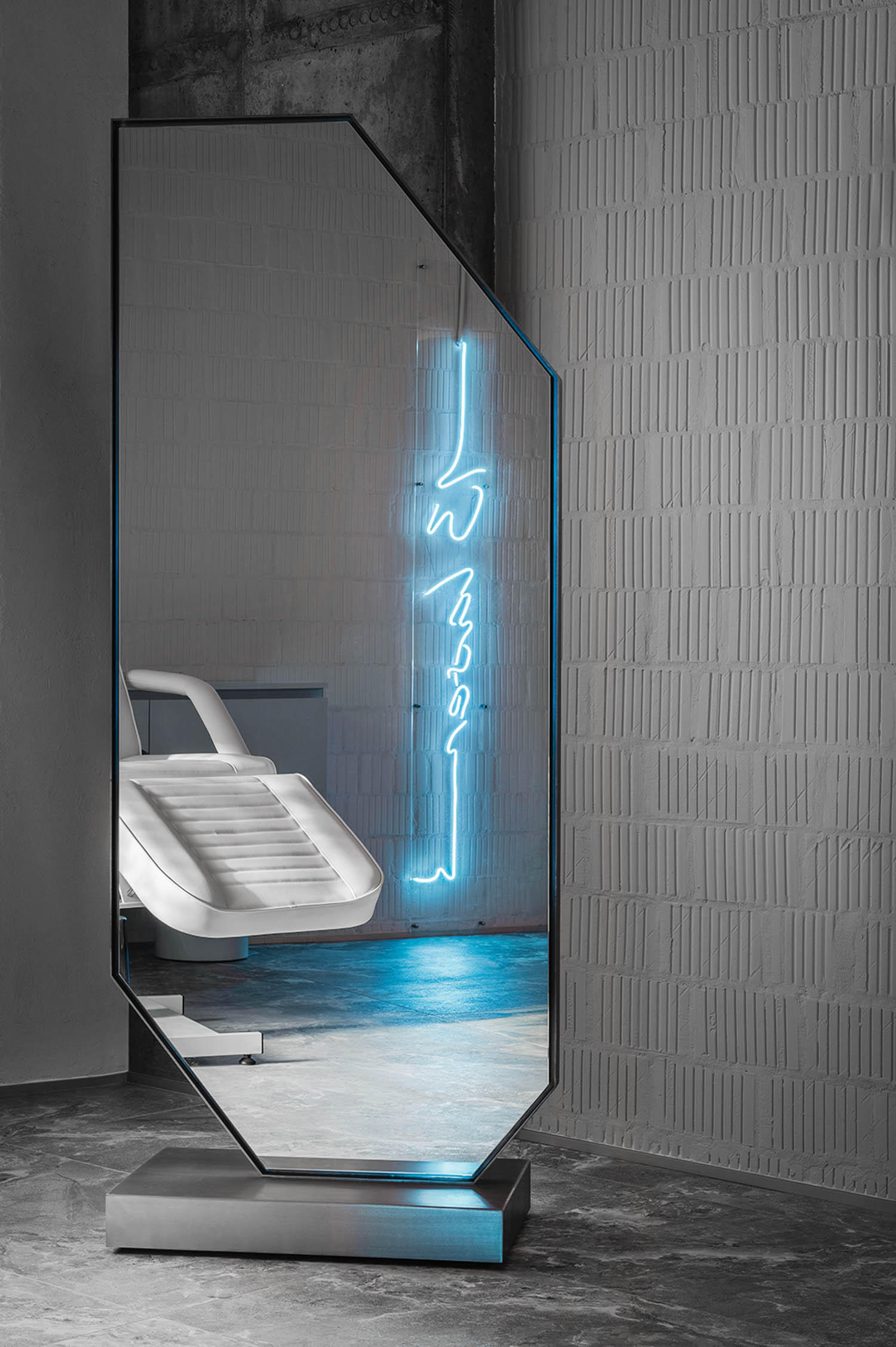 room with grey walls and neon blue writing on the wall