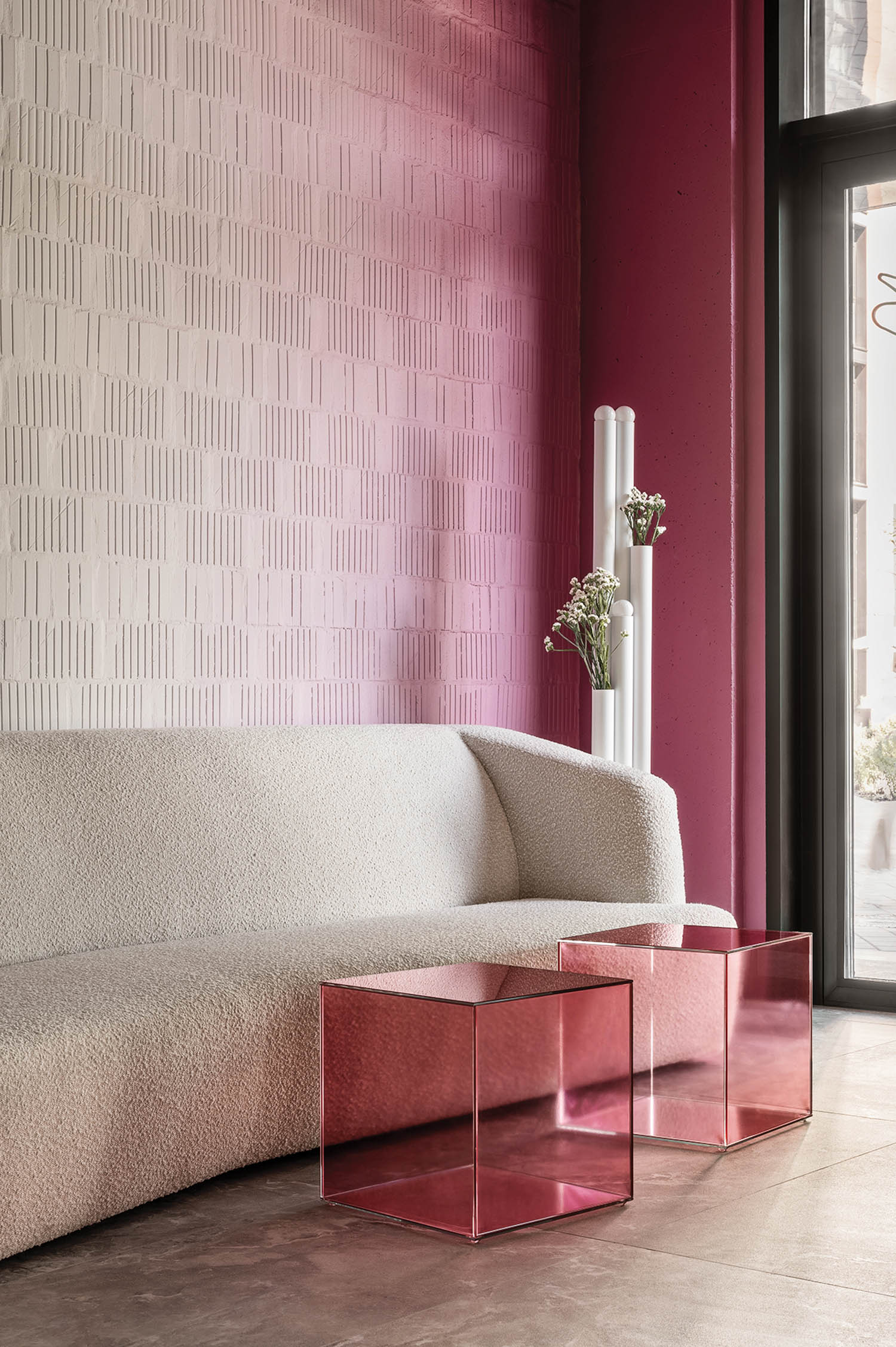 waiting room area with white couch and pink themed tables