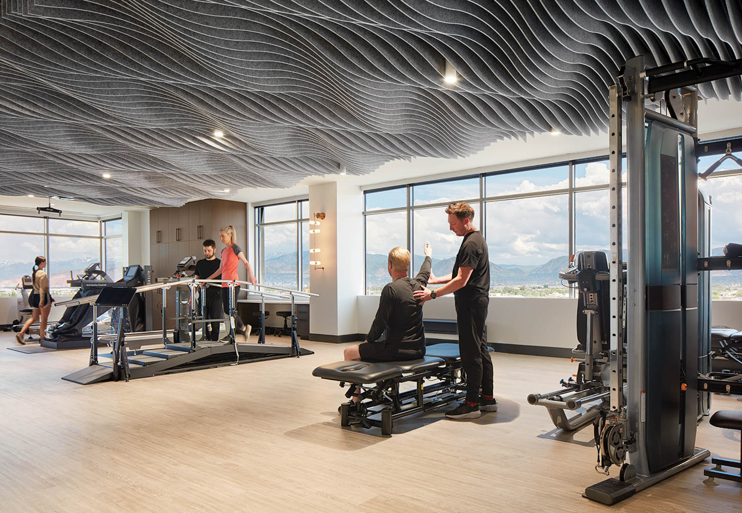 gym space with trainer and visitor sitting on a black bench