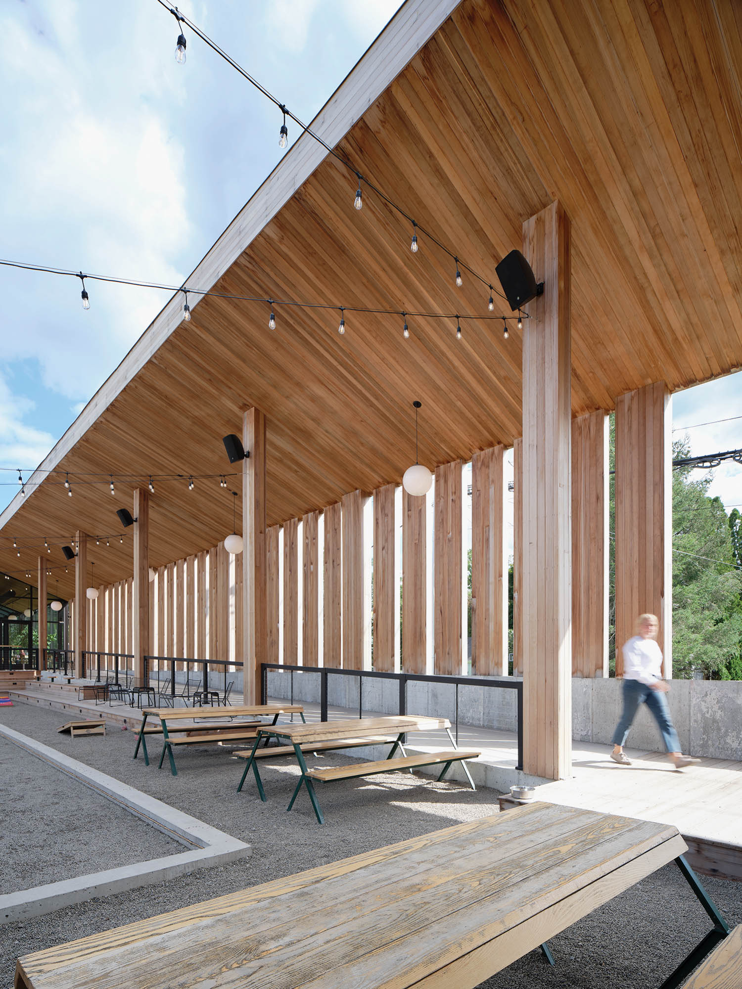 long hallway area with tall wooden ceilings and columns and park benches