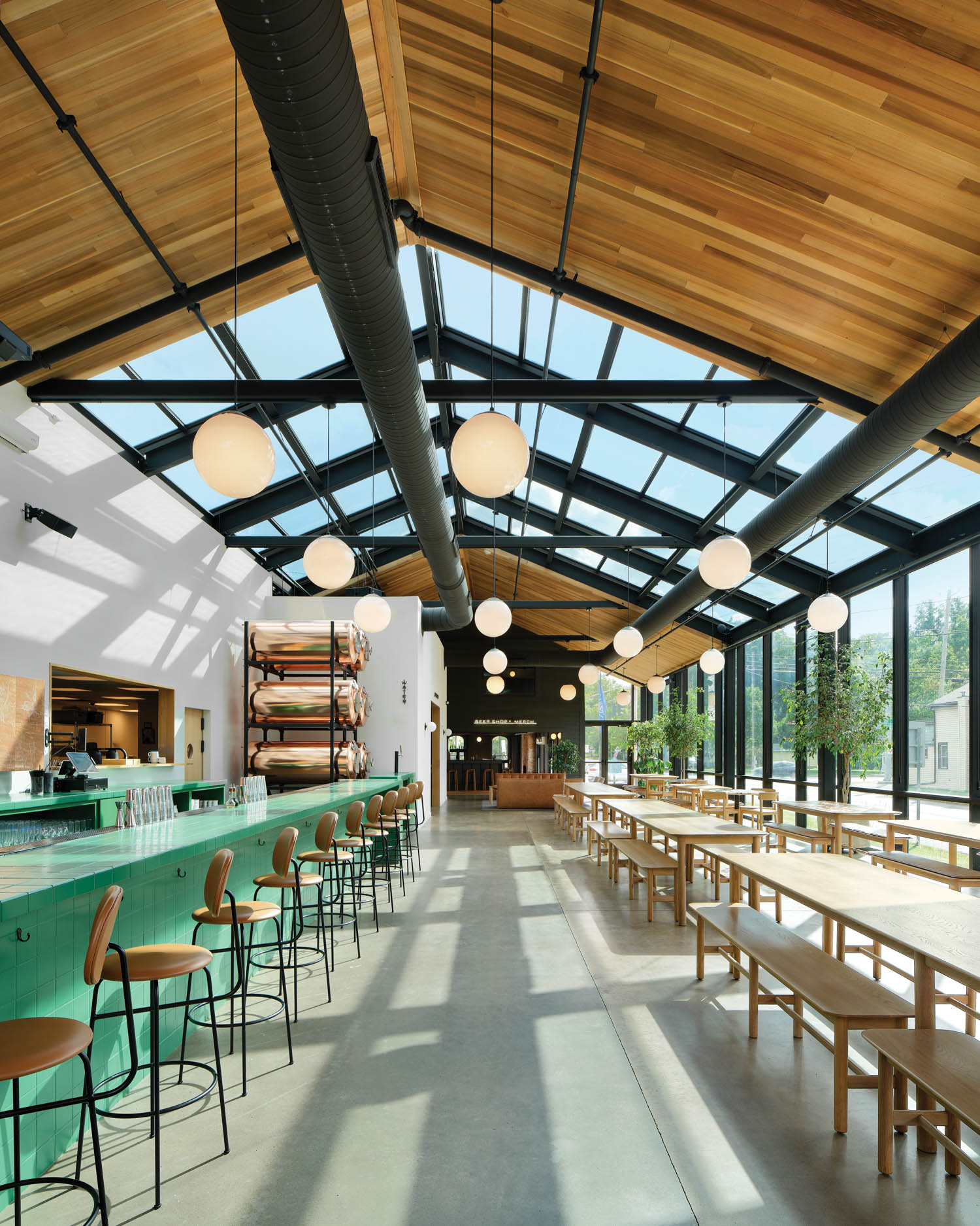 dining area with mint green bar and wooden tables