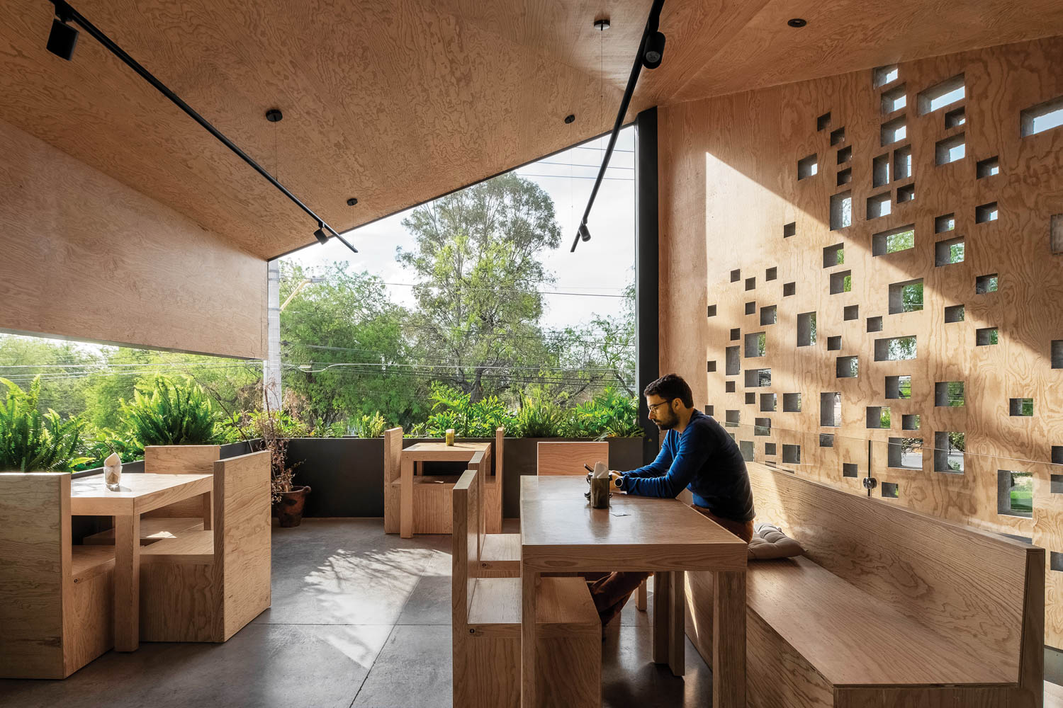 dining area with wooden tables and engraved cutouts on the wall